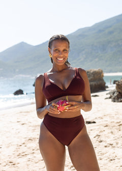 High-leg bikini bottoms in sienna by Lilja the Label, shown with high waist and worn with bikini top on beach.