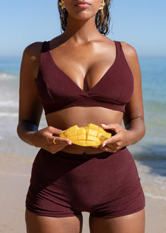 Maroon plunge top by Lilja the Label with textured fabric, worn with matching shorts and earrings.